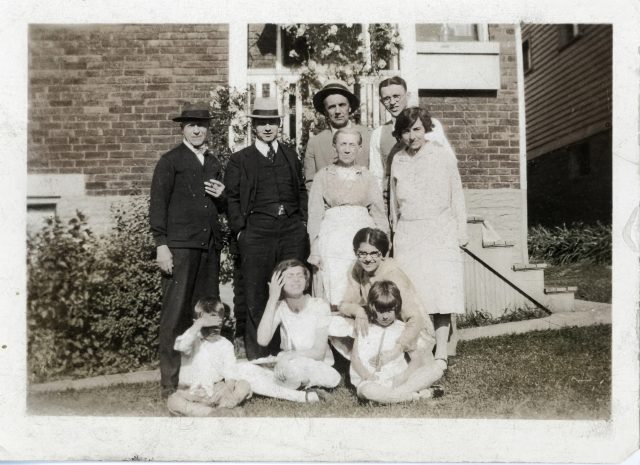 Alois J. Willke Family. Rear of home at 1017 Lockman Avenue, Cincinnati, Ohio. Undated. Men Standing L-R: Alois J. Willke, Al H. Willke, George Willke, Edgar Willke. Women Standing L-R: Tanta Willke (sister of Alois), Ada (Willke) Limke. On ground L-R: Lou Limke, Marcella (Willke) Austing, Lucille (Willke) Vehr (with glasses), Margie (Willke) Landen.